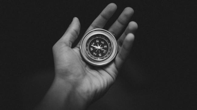 Hand holding a compass